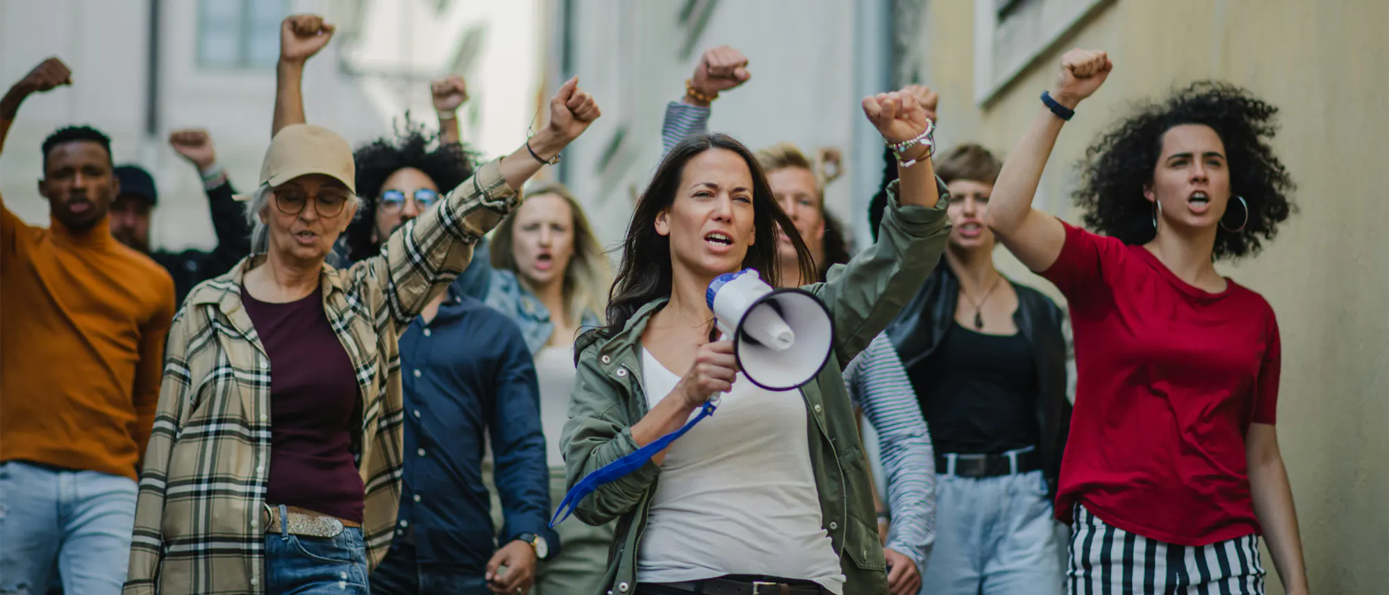 crowd of protesters with arms in the air, megaphone