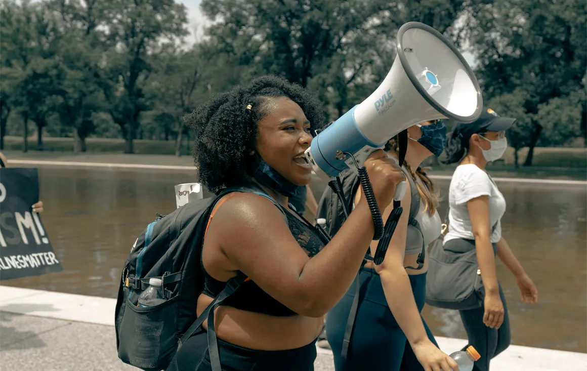 Woman in a crowd talking into a megaphone