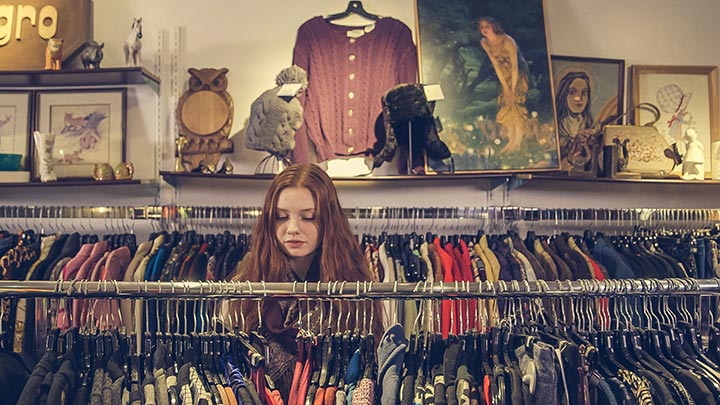 woman at charity shop looking through clothes