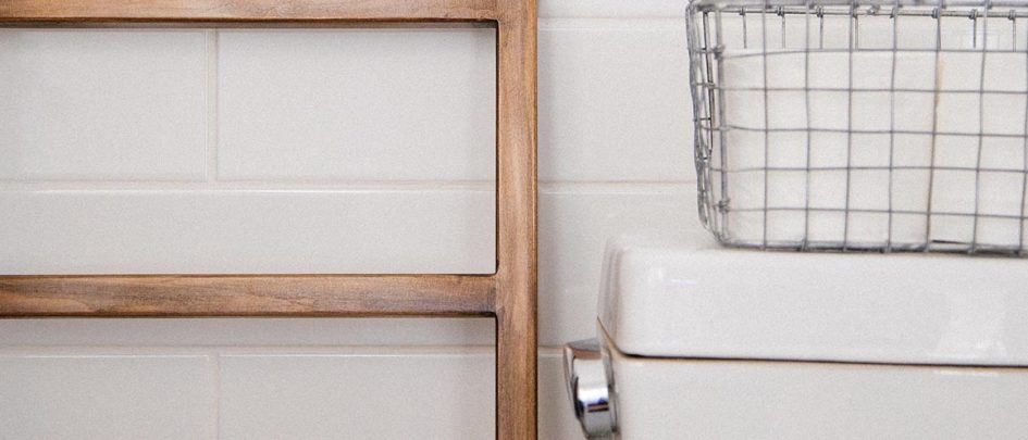 close up shot of toilet, basket and ladder in bathroom