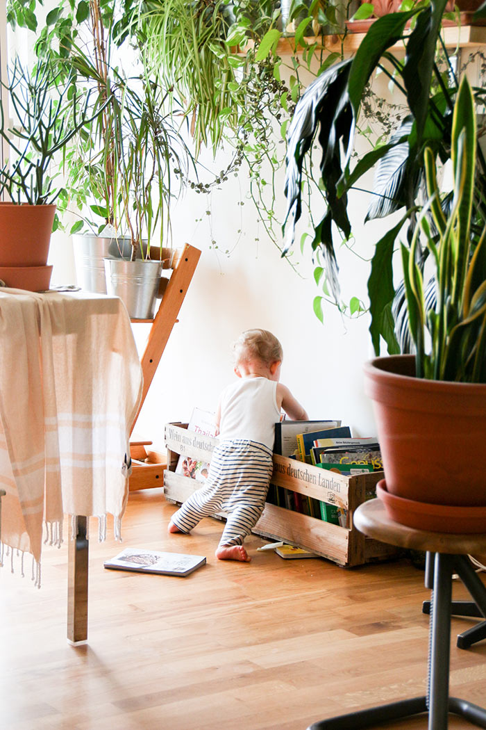 baby looking through books in living room