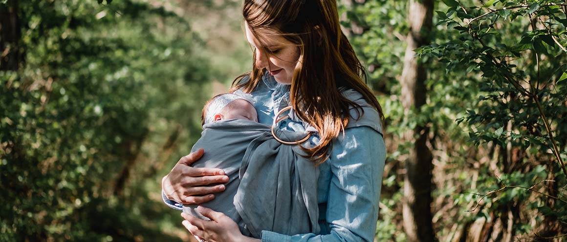 mother holding baby in forest