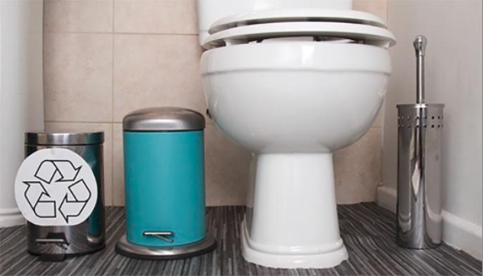 une toilette à côté d'une poubelle normale et une poubelle de recyclage