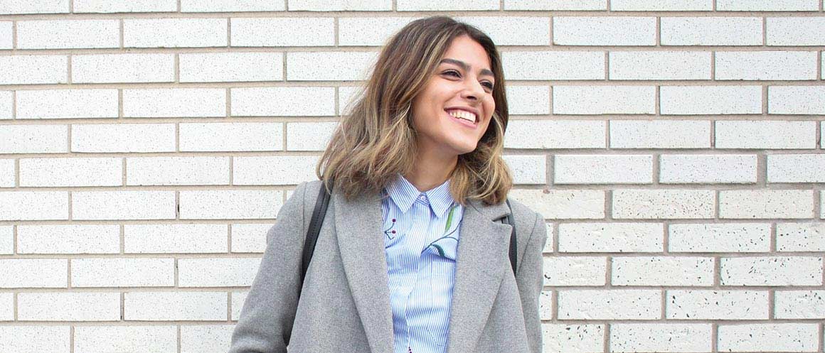 woman smiling against brick wall