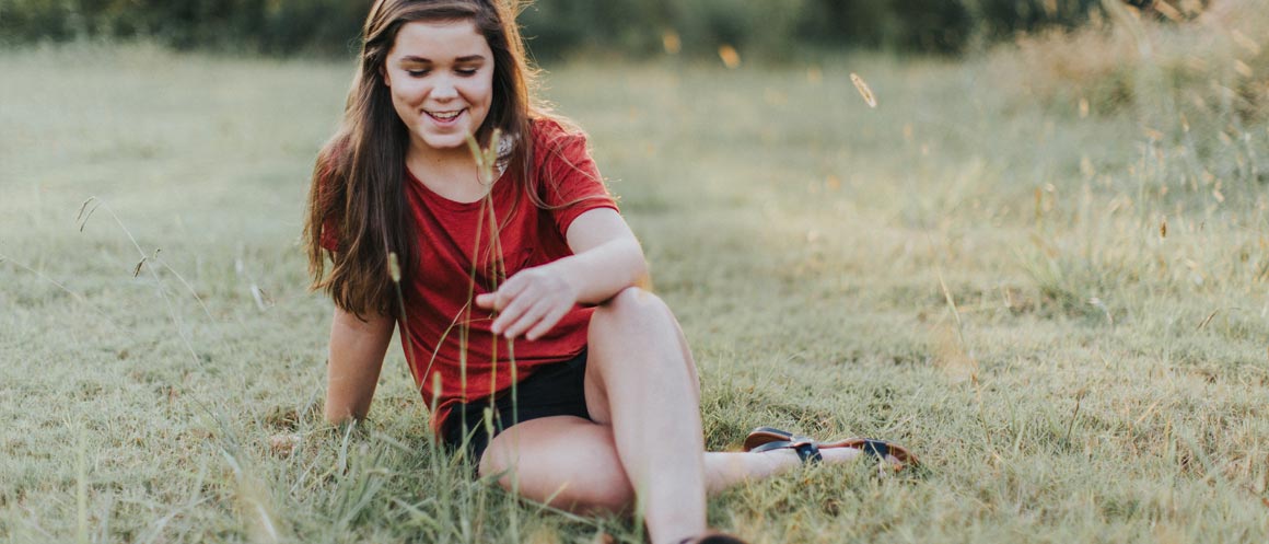 girl sitting happily in field