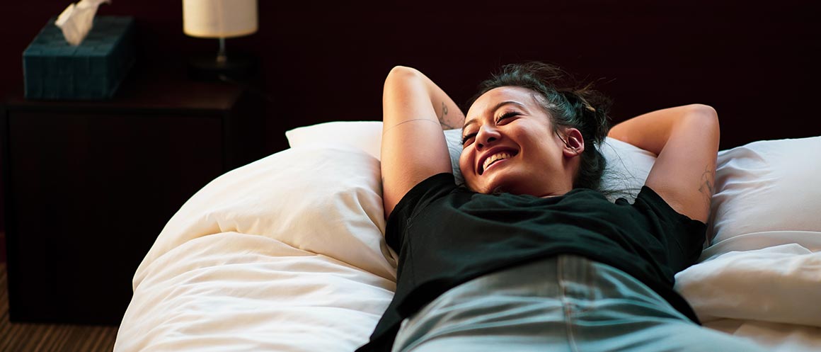 girl casually lying on bed smiling