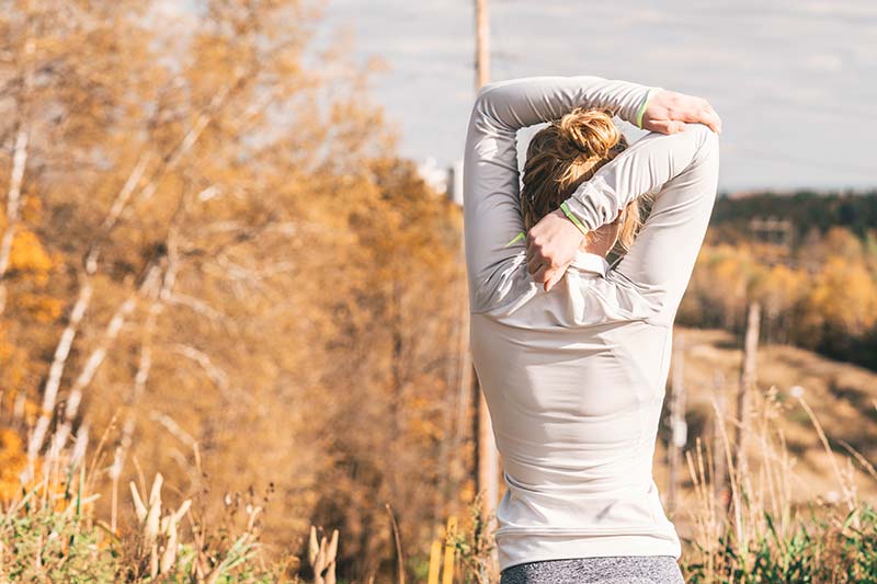 Frau macht Dehnübungen vor dem Sport