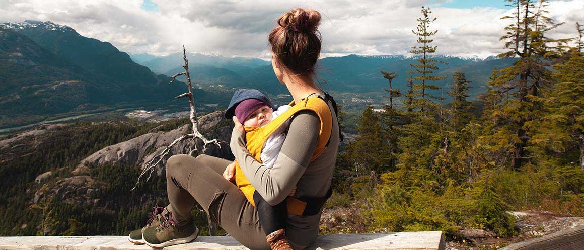 woman looking into the distance holding her baby