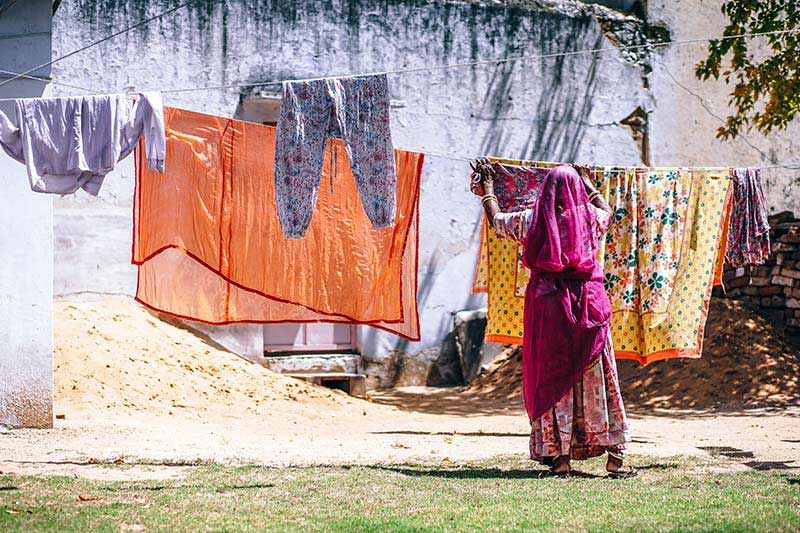 Lady hanging out beautiful saris and fabrics
