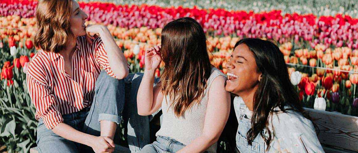 femme presenting friends laughing together