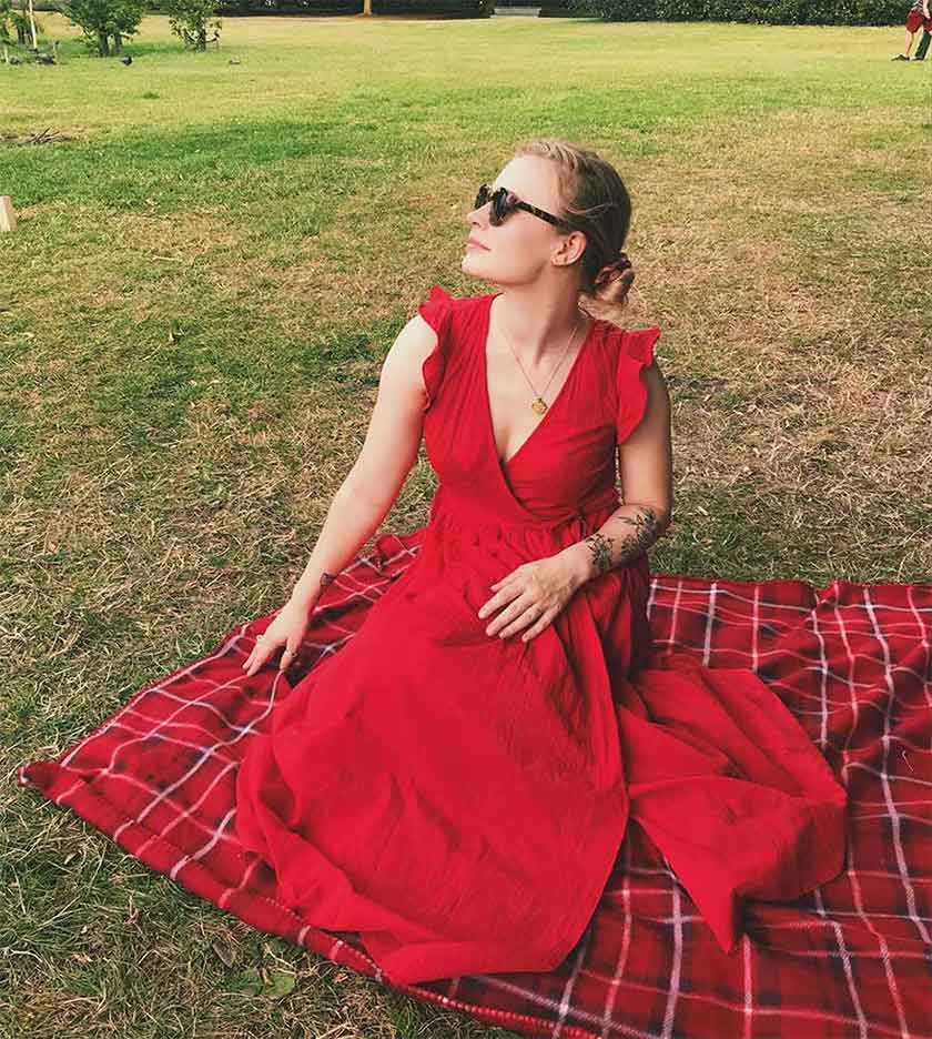lex croucher wearing red on a picnic blanket