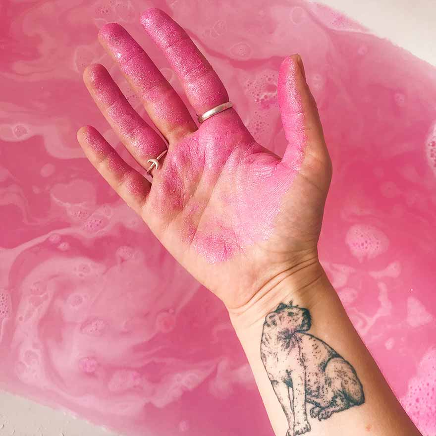 hand with pink glitter and wrist tattoo