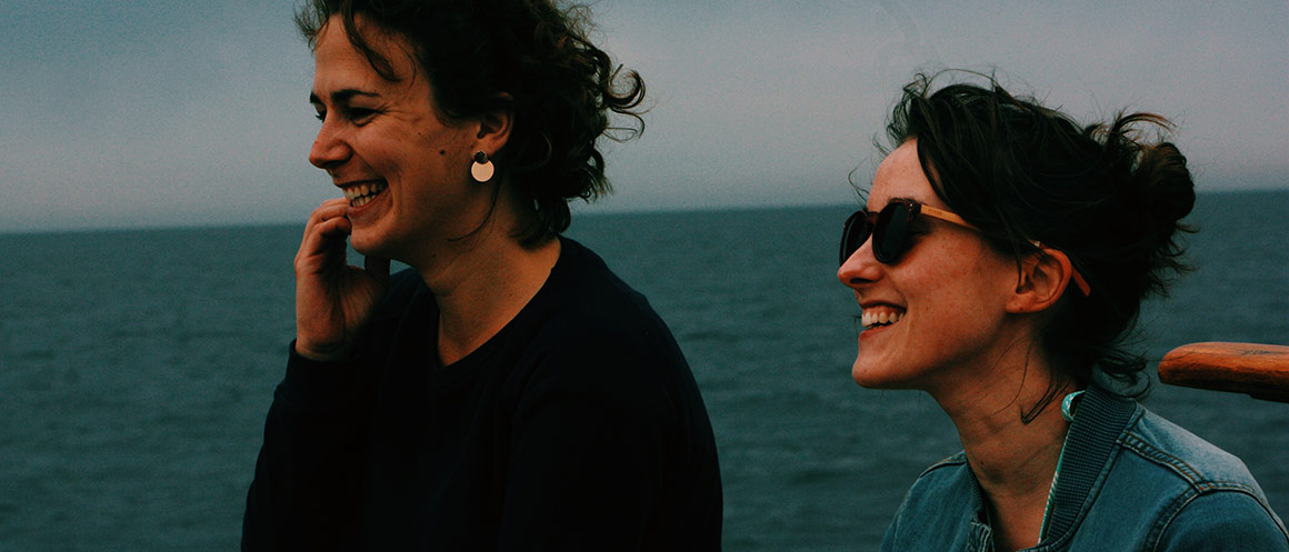 two women laughing looking out to sea