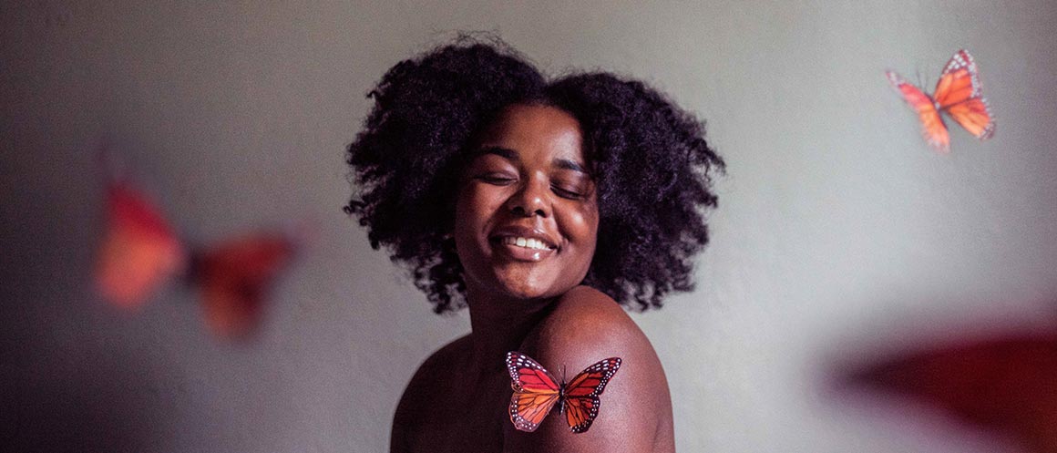 topless woman smiling with butterflies flying around