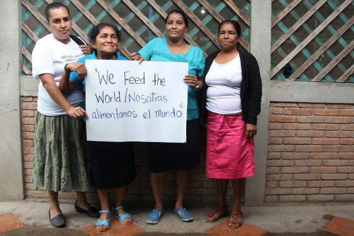 we feed the world photography Frauen stehen zusammen und halten ein Schild hoch