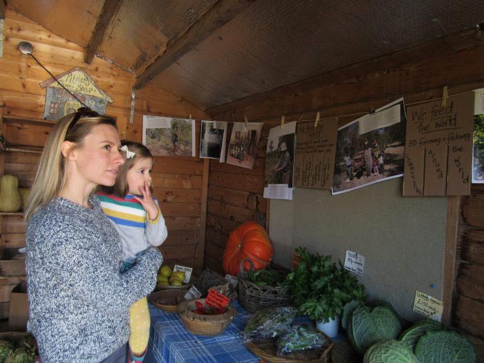 woman holding child looking at photographs in barn