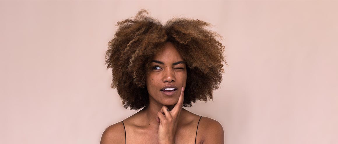 woman thinking against pink background