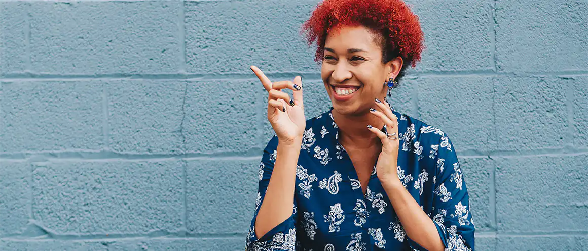 woman with red har smirking and pointing