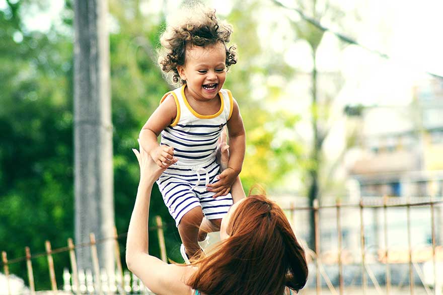 Mother throwing little girl in air