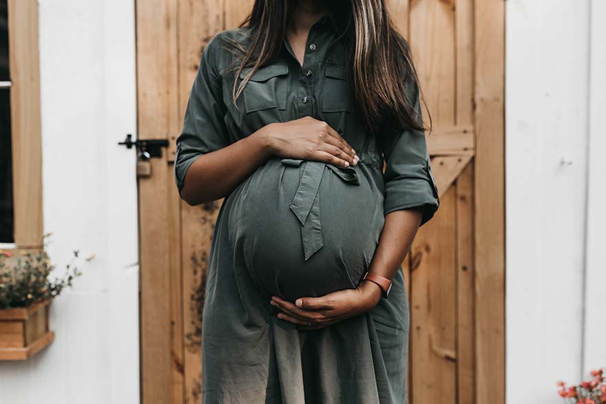 Woman cradling pregnant tummy