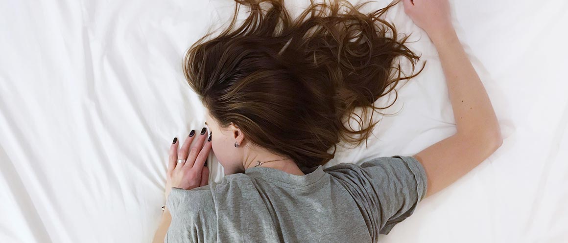 Woman lying face down on a bed