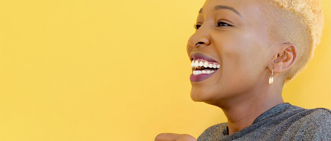 woman laughing on yellow backdrop