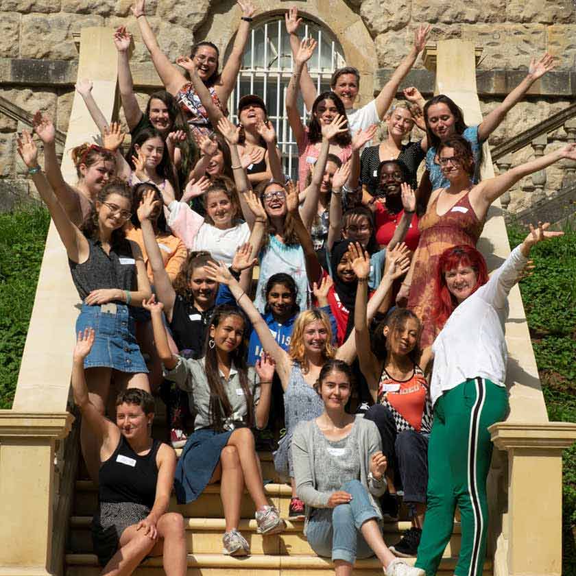 un groupe de femmes et de filles installées sur des escaliers, partageant un moment joyeux