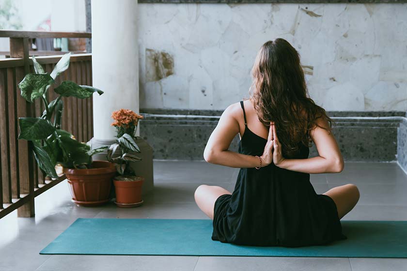 Frau in Yoga Position auf Balkon