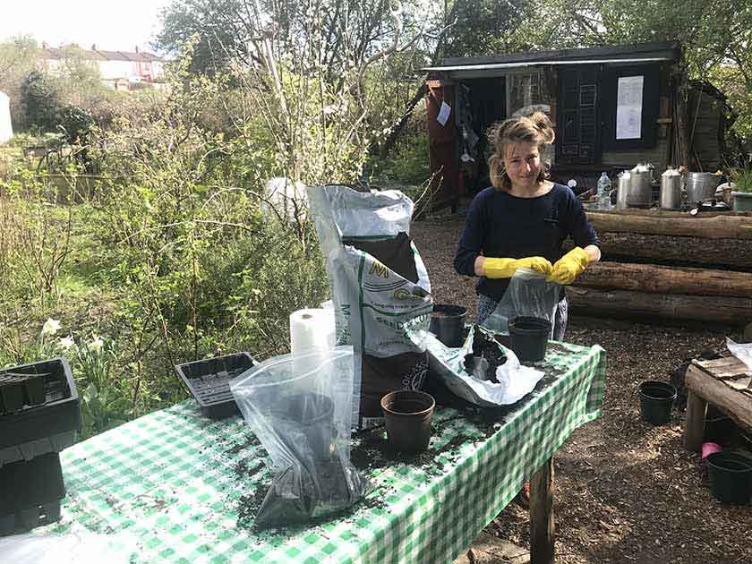 Une personne debout avec un sac de compost