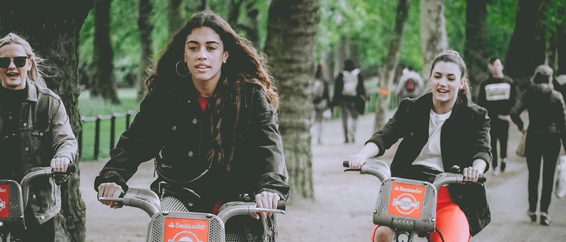 women riding bikes in park