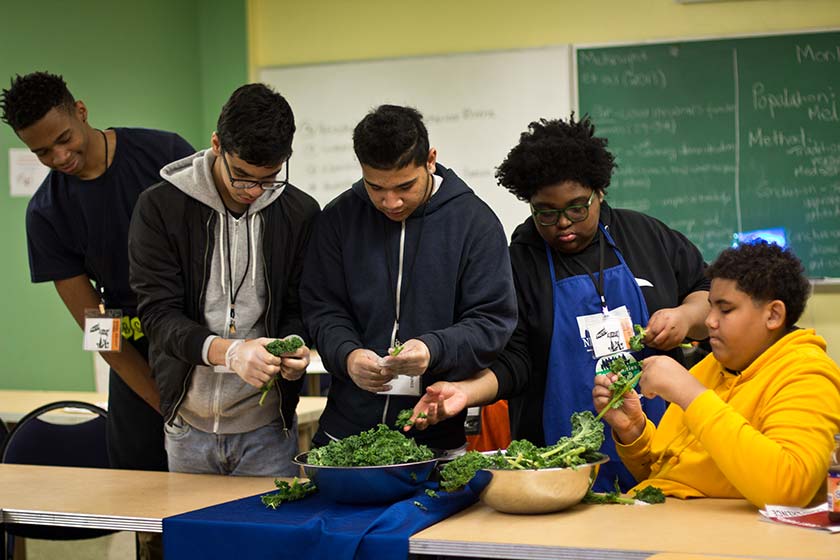 Des garçons qui préparent un repas ensemble dans le cadre du groupe des jeunes