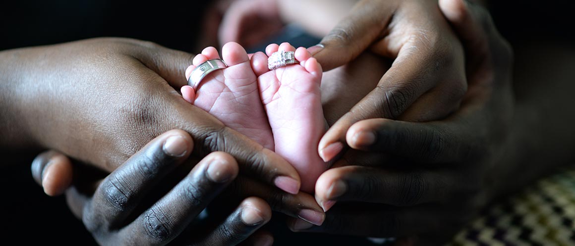 Parents holding their baby's feet