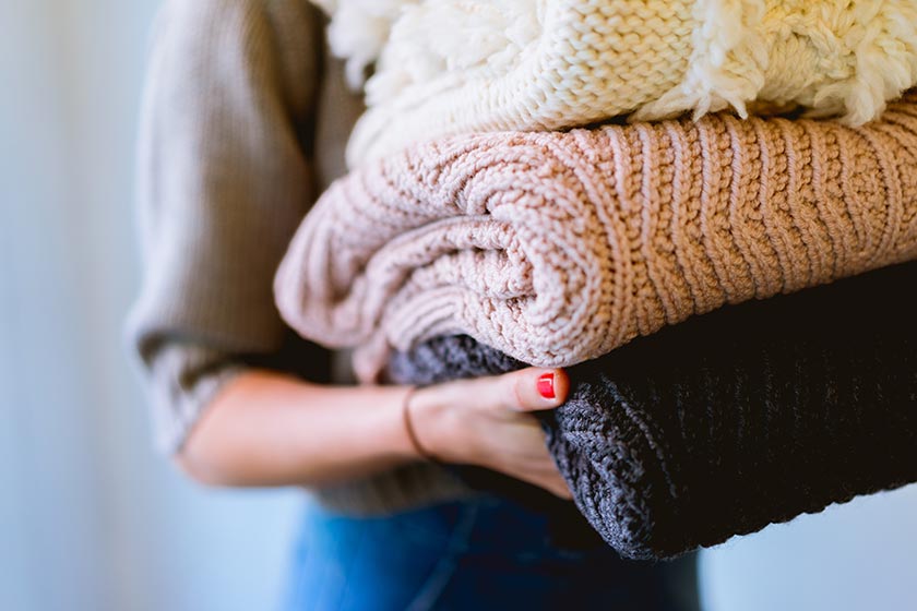 woman holding a pile of laundry