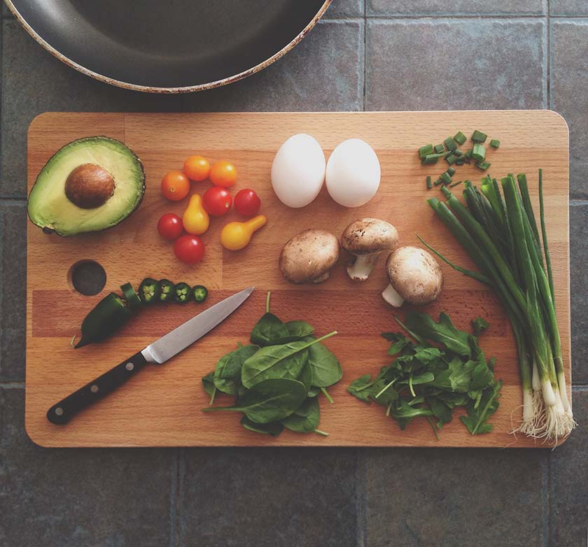 vegetables, fruit and eggs on chopping board