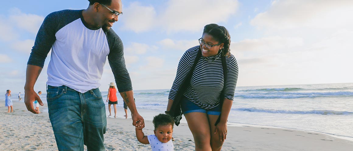 parents walking with their child on the beach