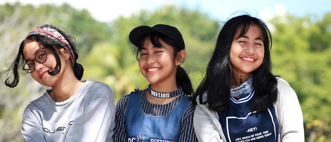 Tres chicas riendo juntas en el exterior