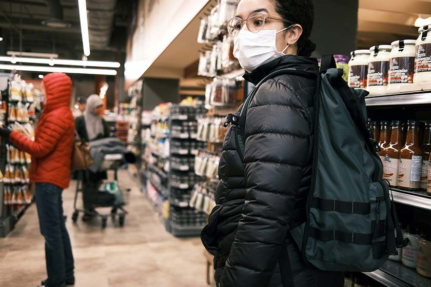 A picture of a woman in the supermarket, wearing a mask