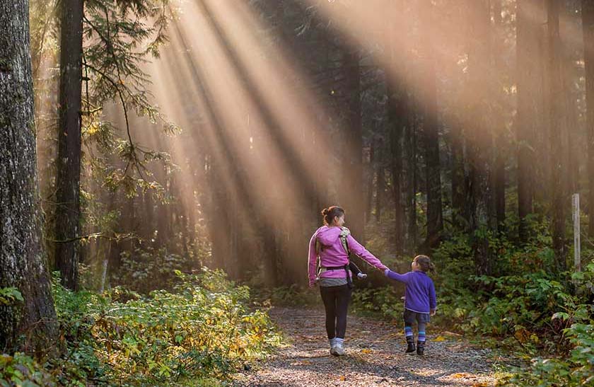 mother and daughter walking in the woods