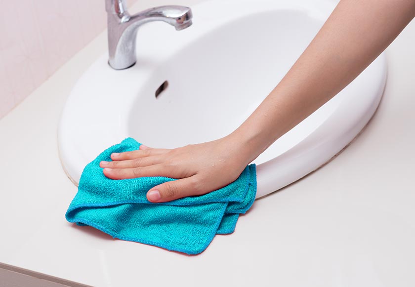 person cleaning with microfibre cloth