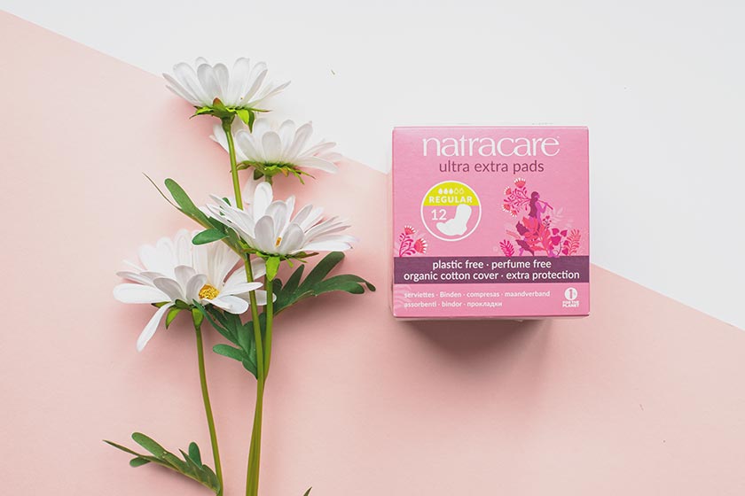 Natracare Ultra Extra Pads in neuem Design mit weißen Blumen neben der Packung