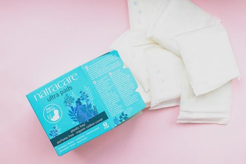 natracare ultra pads new packaging on a pink background with pads coming out of the box to the right