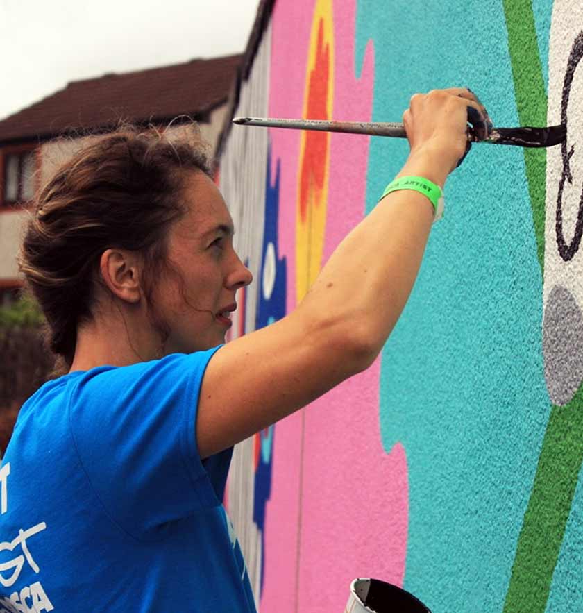 Zoe Power painting a mural