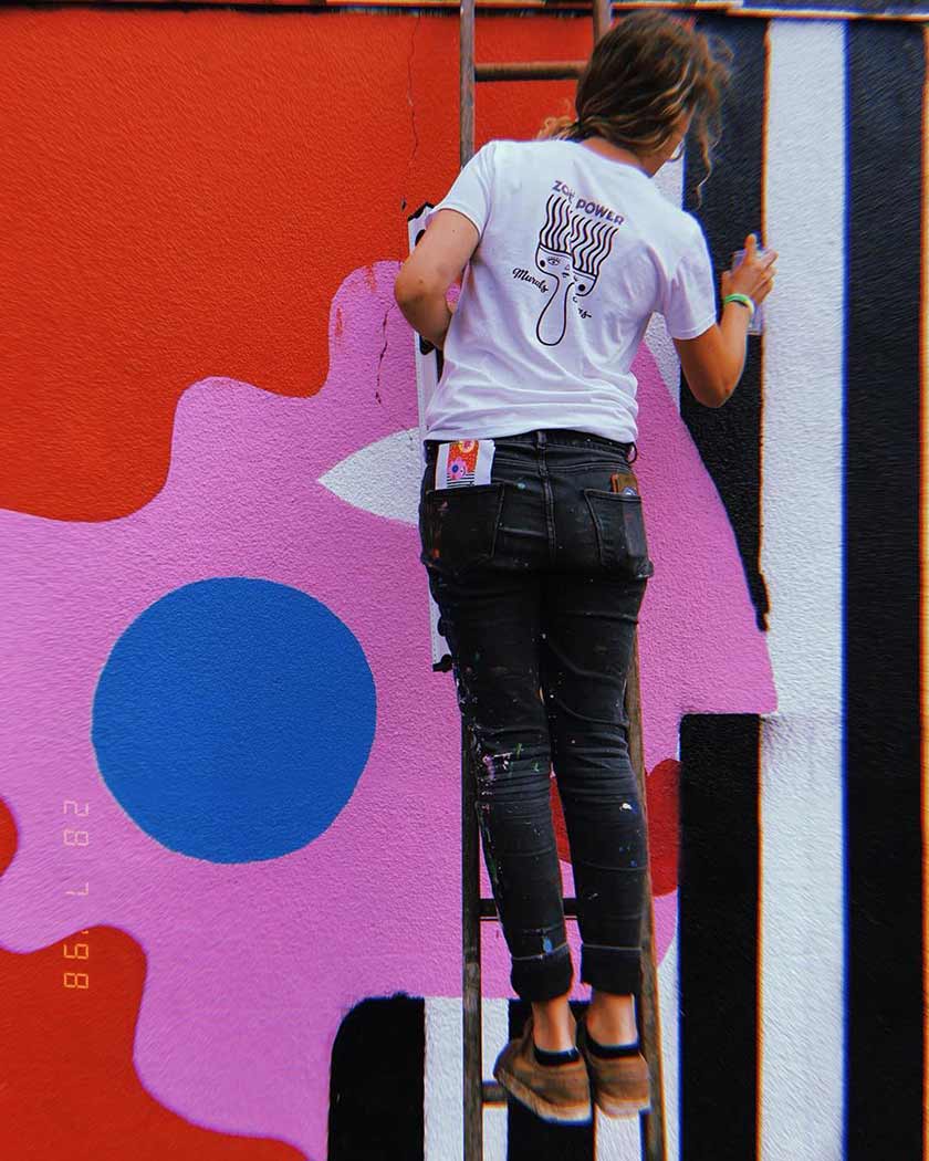 Zoe Power painting a mural