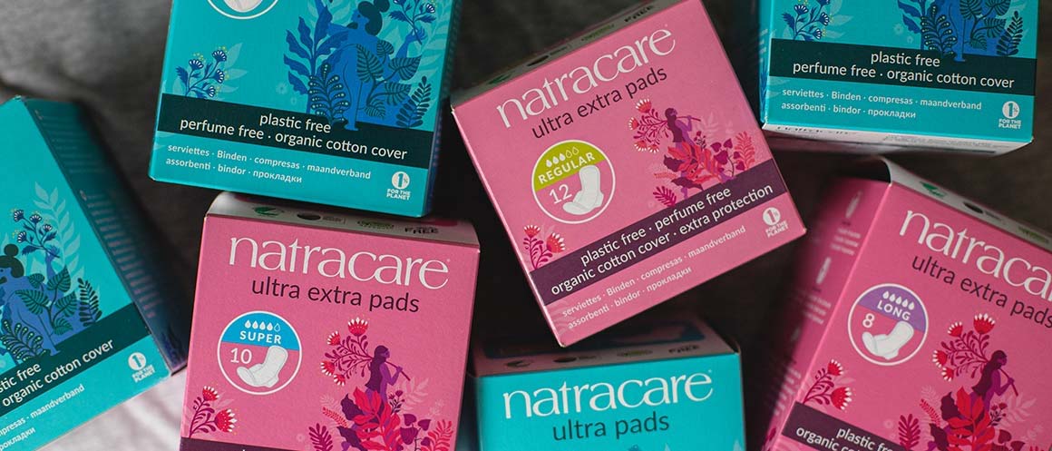 Natracare boxes of pads on a bed