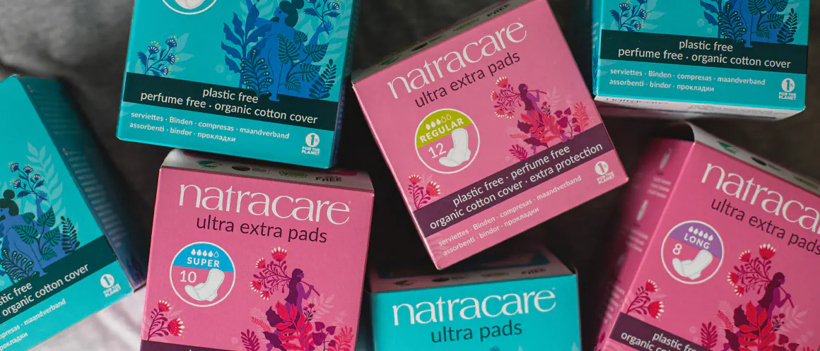 Natracare boxes of pads on a bed