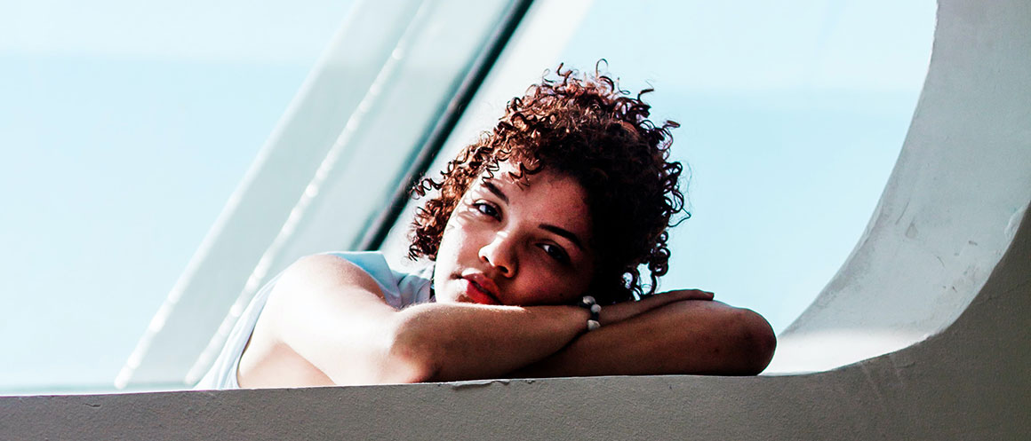 person leaning by window sill