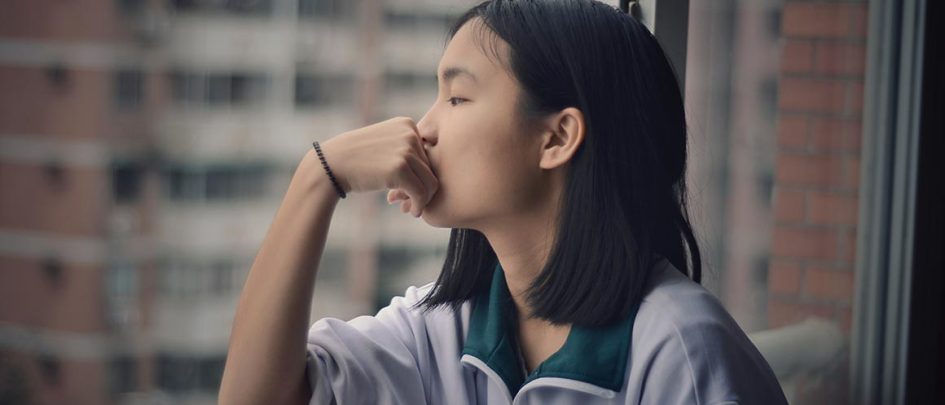 person contemplating by a window