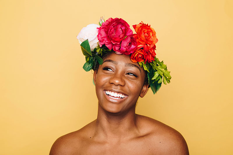 Femme portant une couronne florale et souriant