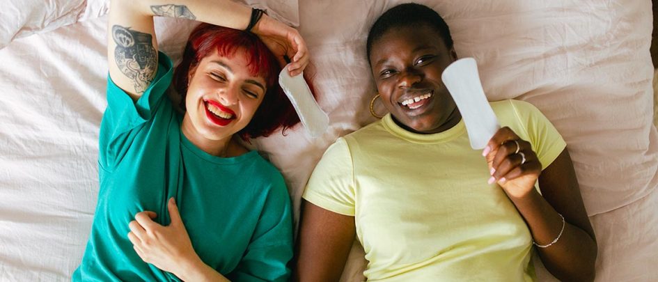 Two people lying on a bed with panty liners
