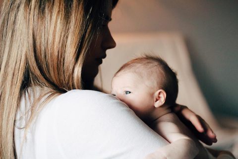 Ouder die een pasgeboren baby vasthoudt